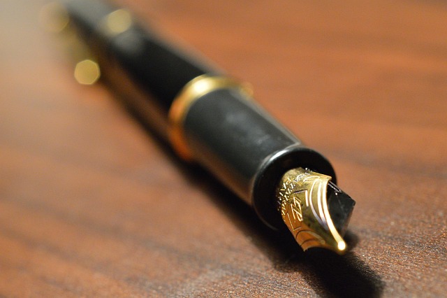 Calligraphy nibs and a brass-toned holder on paper